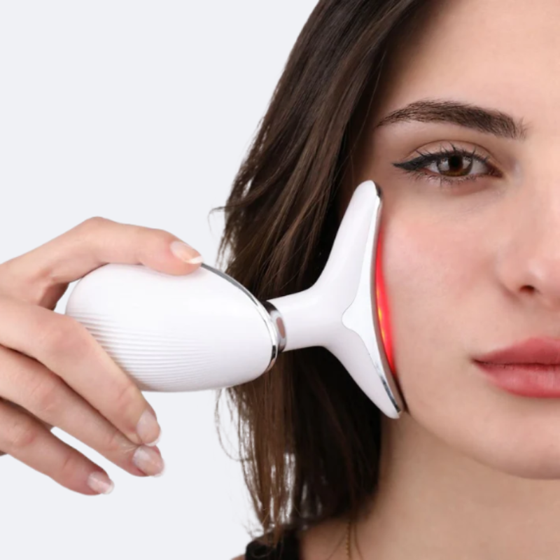 Femme utilisant le sculpteur de visage VELURA avec LED rouge sur sa joue
